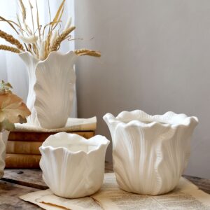 vaaleat kukkaruukut eri koossa pöydällä