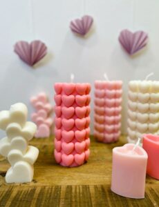 kauniit kynttilät eri väreissä sydämillä ovat pöydällä