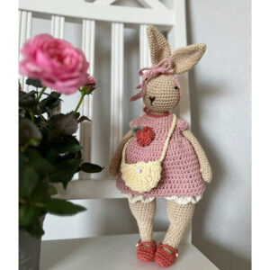 virkattu pupu puuvillaa vaatteiden päällä seisoo tuolilla